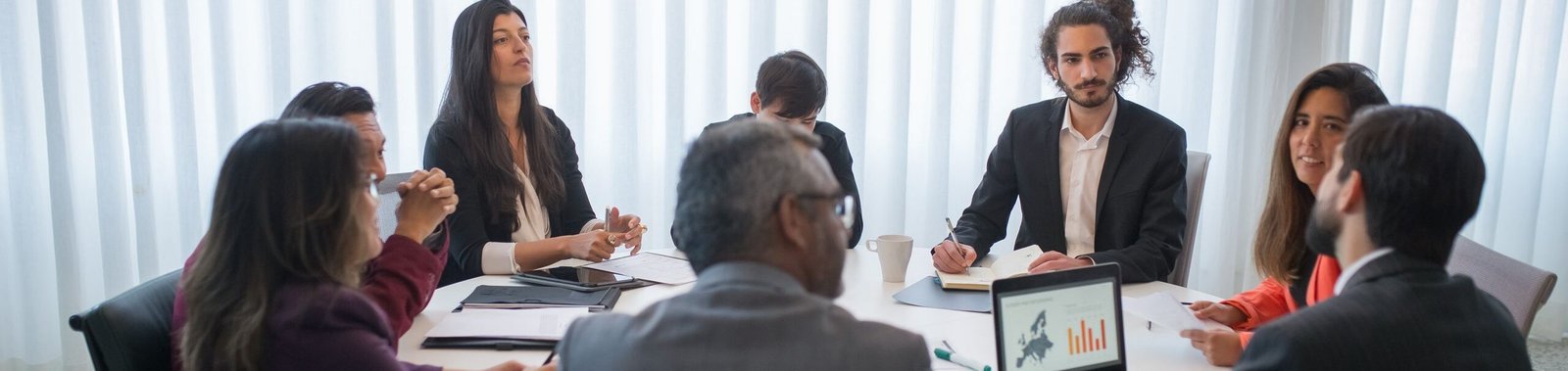 A diverse group of professionals discussing business strategy in a modern office setting.