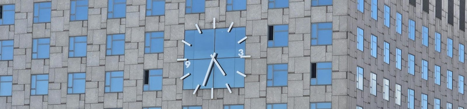 Facade of Catalonia Barcelona Plaza featuring windows and a prominent clock design.